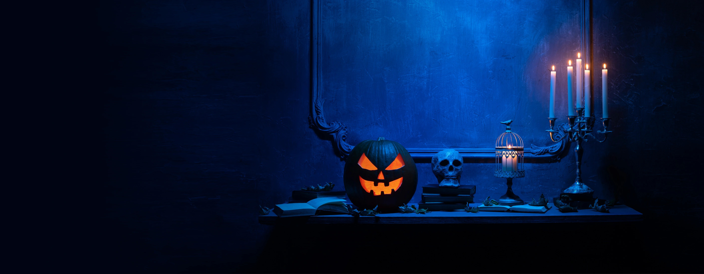 Halloweendekor med pumpa, dödskalle och tända ljus